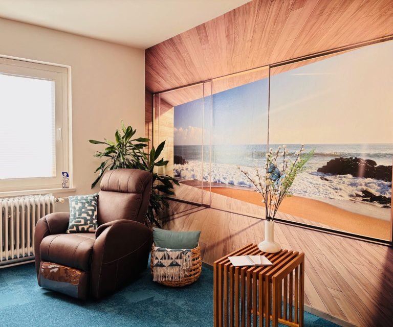 Gemütlicher Raum mit braunem Sessel, Holzoptik-Wand und Meerblick-Dekor.